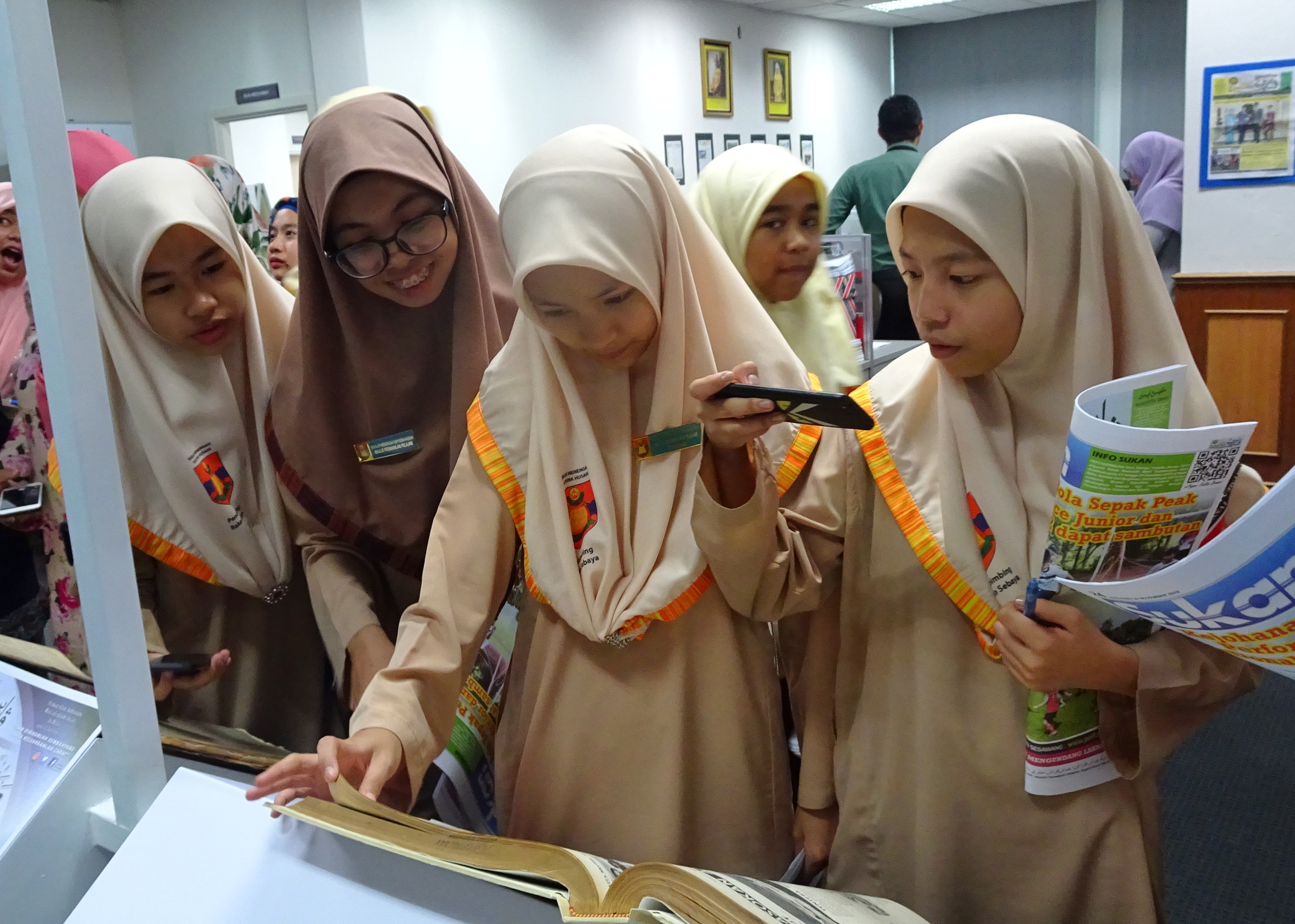 Para peserta lawatan melihat naskhah-naskhah Pelita Brunei terdahulu yang dipamerkan di Unit Pelita Brunei.jpeg
